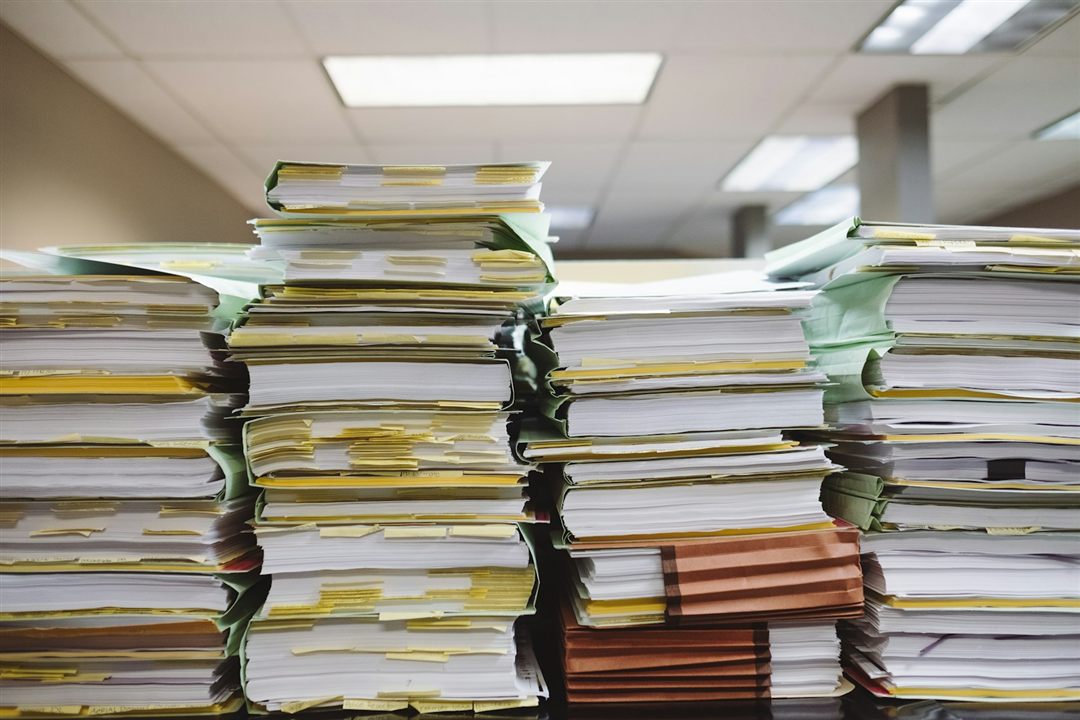 Stacks of paper files waiting to be processed