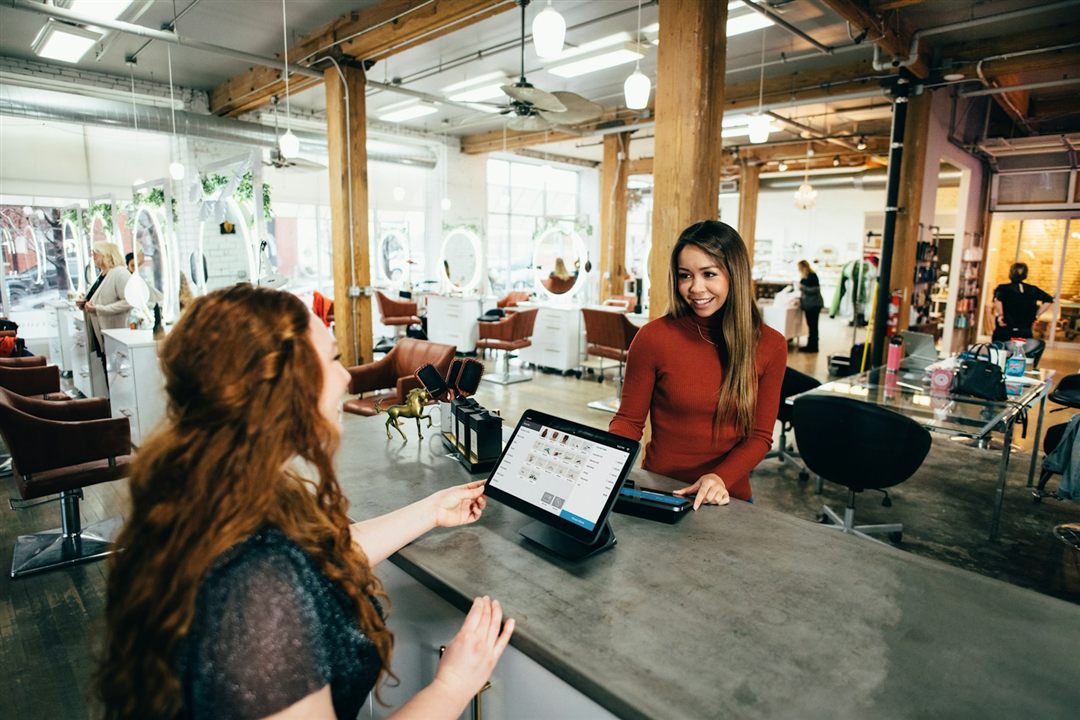 Small business owner serving a customer at a point-of-sale system